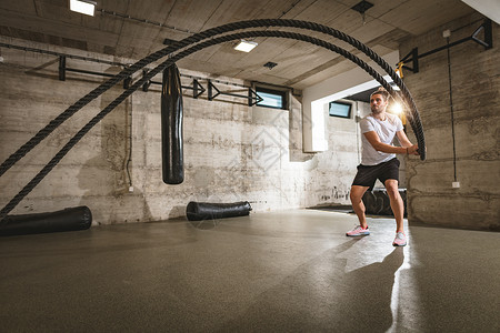 抓住生命如抓绳索肌肉运动男人运动员训练健身房专注力量生活方式水平背景图片