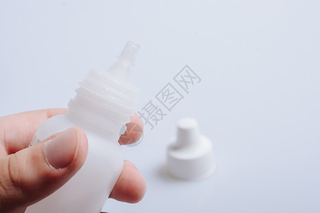 小喷瓶手持白色背景上的白色空撒泡器瓶子背景