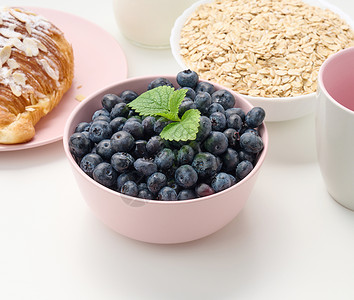 熟熟的蓝莓 粉红色陶瓷板 在白桌上 早餐配料高清图片