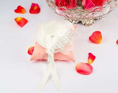 用玫瑰花瓣结婚戒指的漂亮枕头家庭风俗装饰丝带珠宝周年庆典已婚新娘婚礼背景图片