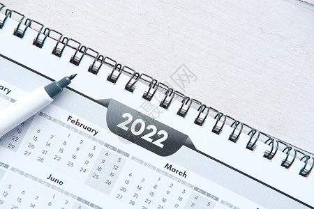 2022 J年办公服务台日历蓝色新年桌子紧迫感白色电脑铅笔笔记本背景图片
