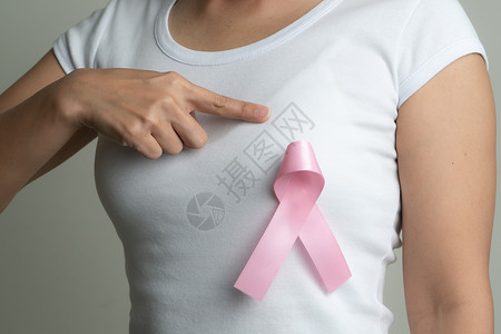 支持乳腺癌病因的胸口妇女胸上粉红色徽章丝带 乳癌认识概念治疗药品帮助胸部机构外科预防幸存者女士保健背景图片