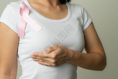 支持乳腺癌病因的胸口妇女胸上粉红色徽章丝带 乳癌认识概念机构女性女士活动治疗卫生保健志愿者胸部肿瘤学背景图片
