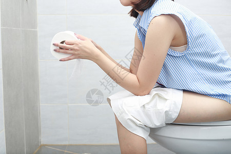 纸马桶穿着浴巾的女人坐在马桶碗上背景