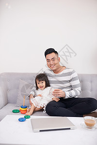 父亲和女儿玩砖瓦控制家庭长椅爸爸父母男人视频沙发游戏背景图片