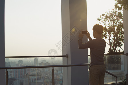 一个人正在用手机拍照电话照片太阳摄影师晴天旅行背景图片