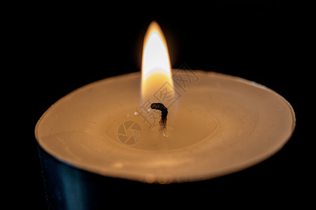黑暗中一根小蜡烛的火焰戒指纪念馆烧伤辉光阴影芳香黑色烛光庆典宗教背景图片
