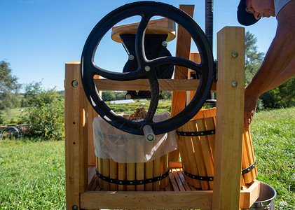 一个男人用传统水果机 和飞轮做苹果苹果汁背景