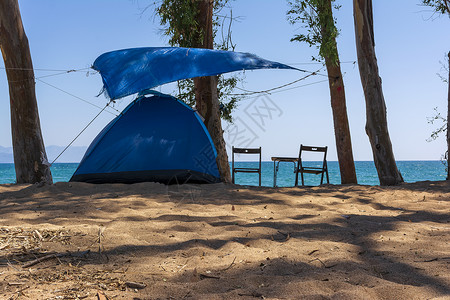 位于梅西尼亚州Velika海滩蓝海附近沙滩上的旅游帐篷娱乐阴影露营闲暇天空旅行海景户外生活天堂假期背景图片