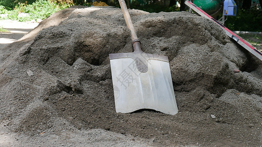 铁质工具铲子用于滴灌的铲子就躺在干水泥或水泥堆上 建筑和开发概念上劳动工人建设者混合器构造工作项目碎石承包商工地背景