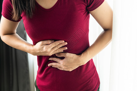 肠胀气妇女因在家里的酸性回流或食道回流而受苦背景