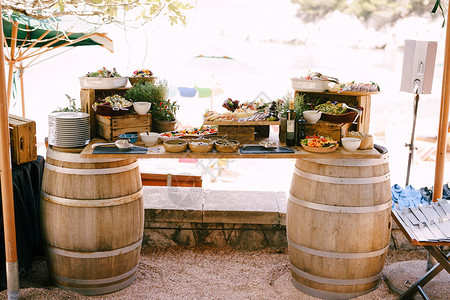 两桶葡萄酒的即兴桌和一木棍 配有美食和鲜花高清图片