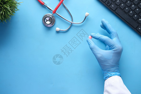 手掌上的单体药片蓝色药品医疗处方医生背景图片