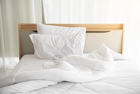 清晨 白色未整理的床铺在优雅的家中 阳光明媚 白色窗帘背景 室内设计和豪华家具概念 室内生活方式和懒惰活动主题床垫公寓奢华酒店织背景图片