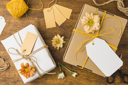简单标签绑有标签绳的包装礼品 美丽的花朵木质表面 高品质照片背景