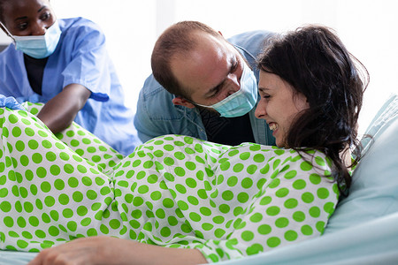 处于痛苦中的年轻妇女在分娩时急迫分娩父亲产妇病人保健女士诊所孩子母性女性送货背景图片