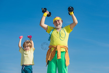 祖父和儿子做运动 父亲和孩子们在锻炼 老人和孩子在家庭健身俱乐部 适合孩子的运动背景图片