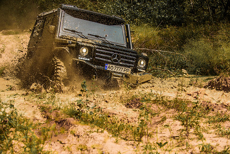 F4赛车越野 4x4 旅行徒步旅行 运动车轮轮胎和越野 与大 4x4 汽车的旅行概念 拉力赛 泥泞是通过湿泥或粘土区域的越野 吉普车户外背景