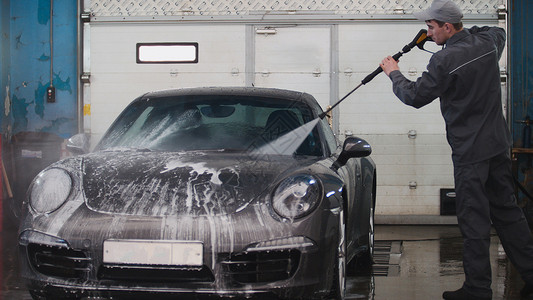 油漆保养券汽车维修的机械设备是用水管洗运动车 用水龙头在板上洗运动车背景