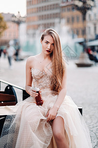 奶油色连衣裙穿着长发婚纱和酒瓶的新娘在老城沃克劳 在一个波兰古城市中心举行婚礼照片拍摄 波兰弗罗克瓦夫Wroclaw亲热连衣裙奶油色冒充饮料背景