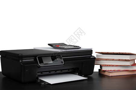 白色背景的黑桌上打印机和书集以及黑桌上的书籍团体桌子黑色扫描器激光印刷床单文档技术商业背景图片