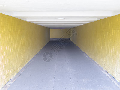 黄色长灯笼空的黄色地下人行横道 隧道和尽头的日光 在人行横道处走到顶部 城市地下有一条带灯笼的长混凝土隧道入口过境行人街道通道建筑旅行楼梯背景