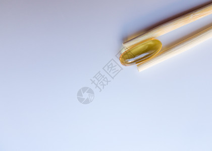 鱼油胶囊用中国筷子 在白色背景上的欧米茄 3 高分辨率产品 食物供给 健康生活方式的维生素 脂肪酸 体内新陈代谢药品胶囊愈合处方背景图片