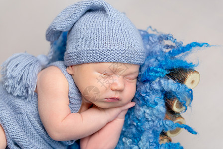 穿着黄毛编织装睡在婴儿床睡觉的婴儿小憩幸福羊毛篮子毯子孩子内裤午睡姿势钩针背景