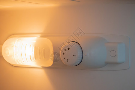 冰箱内部的橙色光亮 紧闭 当门打开来改善视力时 灯就开着 家用电器概念 在冷冻柜中换灯厨房橙黄色按钮团体早餐调节器食物烹饪冷藏农背景