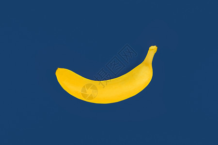 蓝色背景的灰黄色塑料香蕉胶卷背景图片
