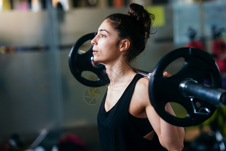 健身房运动举重的体操女运动员盘子女孩身体活动肌肉哑铃活力训练锻炼运动装背景图片