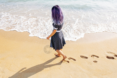 紫色脚印输入框女人在海滩上行走 在沙滩留下脚印背景