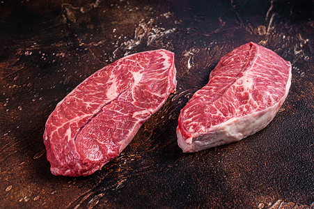 查克牛排Raw 顶尖刀片或肉食餐桌上的平板铁牛肉牛排 暗底背景背景