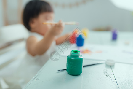 可爱可爱的女婴用水彩色学习绘画活动孩子刷子童年帆布女孩幼儿园创造力艺术艺术家背景图片