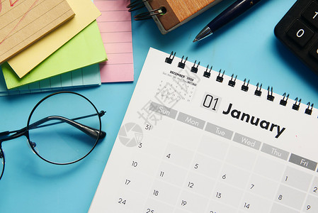 1月1月办公桌日程安排新年紧迫感日历桌子铅笔笔记本电脑蓝色背景图片