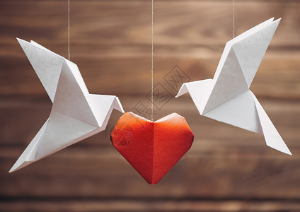 黑白纸鸟机器人两个折纸鸽 围绕红色纸心 情人节贺卡背景