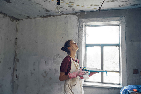 室内装修画家 妇女绘画房屋装饰化妆品画笔刷子木头房子微笑装潢拉丁手臂女孩背景图片