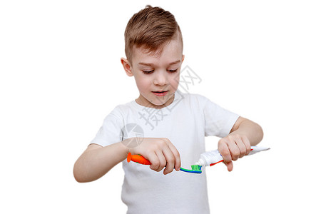 穿白色T恤衫的小男孩在刷子上挤牙膏 保健 卫生和儿童概念 Cary预防背景图片