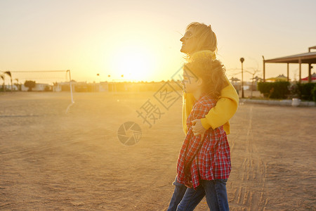 拥抱太阳女孩快乐的母亲和女儿一起走在一起 拥抱户外 日落喜悦享受乐趣幸福微笑闲暇女士童年女性孩子背景