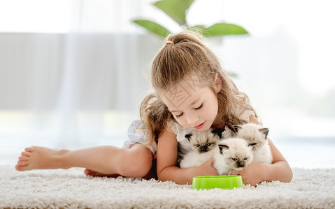 女孩有小猫的破布娃娃眼睛快乐乐趣布娃娃食物动物童年宠物猫咪幸福背景图片