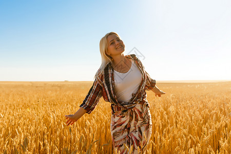 一个女孩在小麦口袋里 白人女人在外面摆着小燕子日落谷物农村女孩地平线钦佩粮食极乐农业太阳背景图片