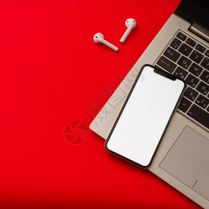 airpod俄罗斯图拉  2019年5月24日 苹果iPhone X和用笔记本印在红色背景上的Airpod小样耳机空白盒子电子产品适配器白色背景