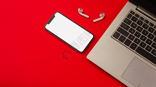 airpod俄罗斯图拉  2019年5月24日 苹果iPhone X和用笔记本印在红色背景上的Airpod空白手机白色展示电子产品音乐气垫黑背景