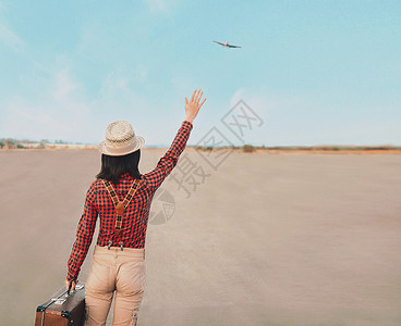 女旅行者挥手到飞机上背景图片