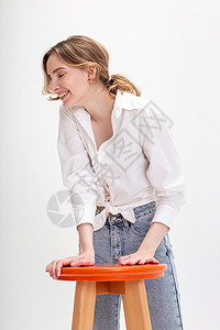 显瘦女装穿着白衬衫 蓝色牛仔裤在工作室大笑的年轻可爱微笑的caucasian女孩背景