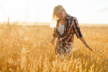 一个女孩在小麦口袋里 白人女人在外面摆着小燕子极乐成人喜悦女性收成农妇享受地平线太阳谷物背景图片