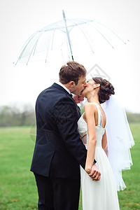新娘和新郎在雨季的结婚日散步女孩夫妇下雨天气黑色婚礼绿色喜悦微笑裙子背景图片