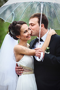 新娘和新郎在雨季的结婚日散步白色婚礼裙子绿色下雨天气夫妇微笑女孩黑色背景图片