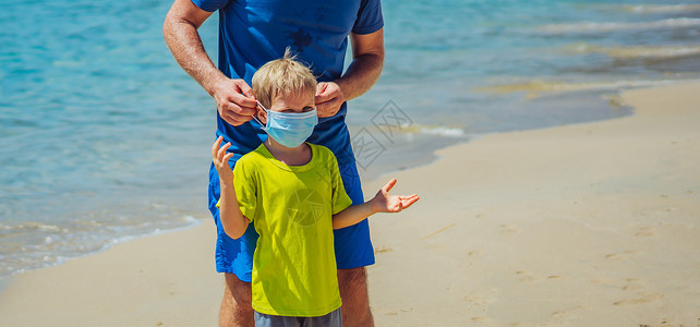 让领养代替买卖正常现实 COVID 大流行 父亲让男孩戴上面具保护冠状病毒 儿子拒绝 不想一直戴着它 厌倦了面具 走在大自然的海滩森林公园太阳背景