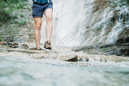 偷渡女孩横渡河流女性瀑布旅行女士远足穿越探险家冒险游客旅游背景